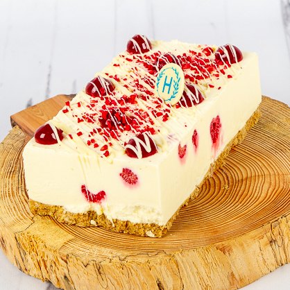 Raspberry and white chocolate cheesecake on a wood slice