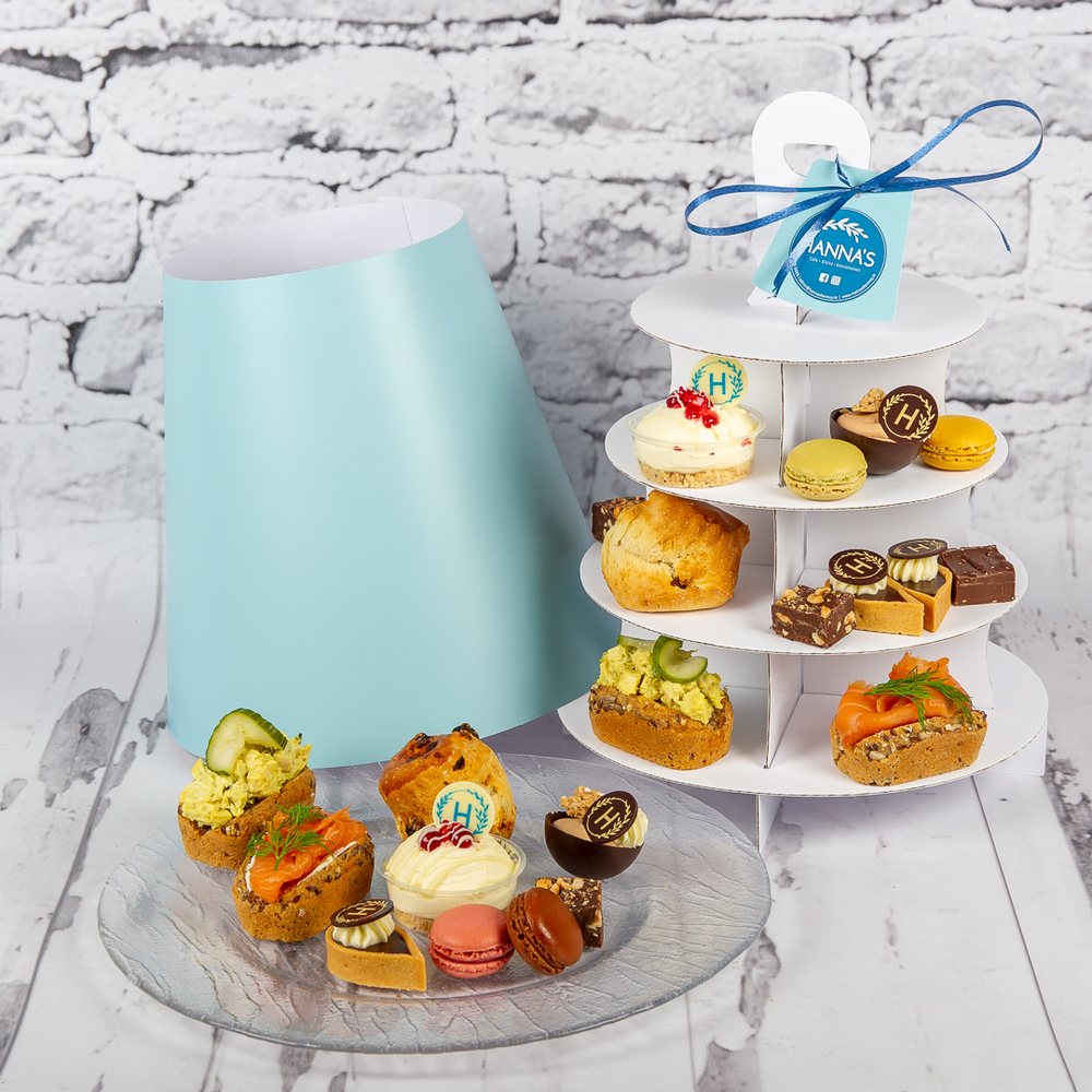 An afternoon tea tower with small savouries, cakes and macarons, and a Hanna's gift tag